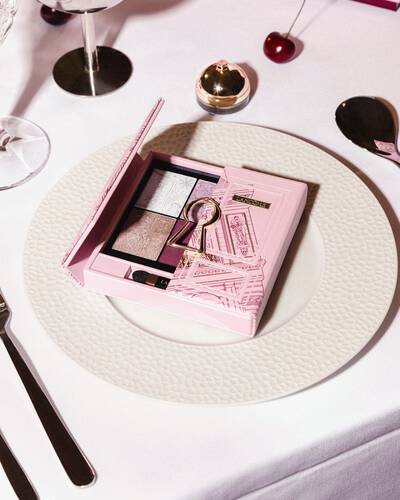 Ružičasta Lancome paleta sjenila za oči s motivom zlatne ključanice, elegantno servirana na bijelom svečanom tanjuru.