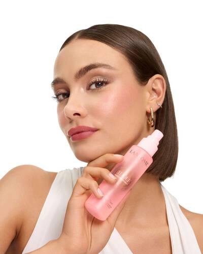 Žena s elegantnim bobom drži Lancome Idole maglicu.