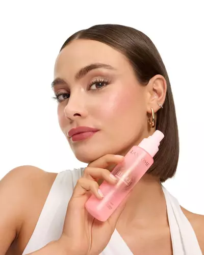 Žena s elegantnim bobom drži Lancome Idole maglicu.