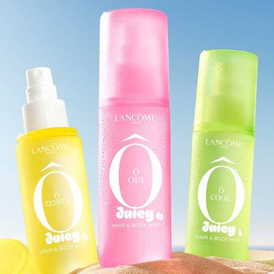 Tri Lancome Juicy Hair & Body Mista u jarko žutoj (O Zenith), ružičastoj (O Oui) i zelenoj (O Cool) boji, odmaraju se na pješčanoj plaži.