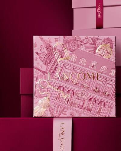 Elegantna hrpa ružičastih i tamnocrvenih Lancome poklon kutija, s centralnom kutijom ukrašenom zlatnim pariškim arhitektonskim ilustracijama.