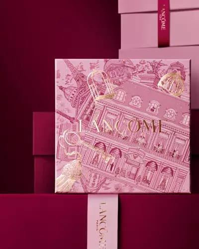 Elegantna hrpa ružičastih i tamnocrvenih Lancome poklon kutija, s centralnom kutijom ukrašenom zlatnim pariškim arhitektonskim ilustracijama.
