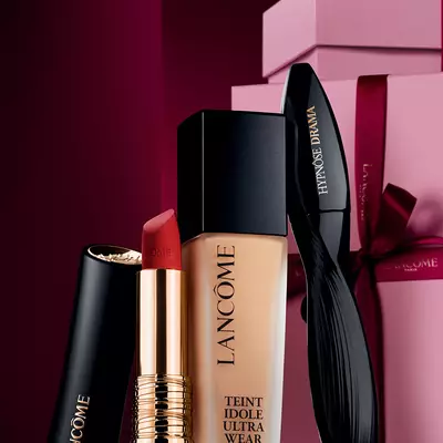 Elegantni slikovni prikaz Lancome L'Absolu Rouge mat ruža za usne, Teint Idole Ultra Wear tekućeg pudera i Hypnose Drama maskare na luksuznoj tamnocrvenoj blagdanskoj pozadini.