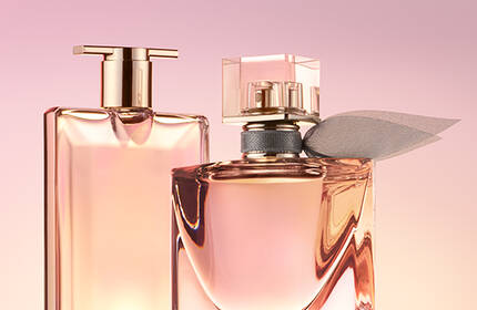 Two elegant perfume bottles are displayed against a soft pink background. One bottle has a sleek, rectangular shape, while the other is more rounded and adorned with a decorative element.