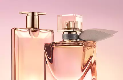 Two elegant perfume bottles are prominently displayed against a soft pink background. One bottle has a sleek rectangular shape, while the other is more rounded with a decorative accent.