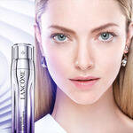 Žena s blistavom kožom i plavim očima uz Lancome proizvod za njegu kože.