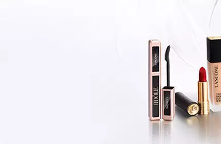 A minimalist display of Lancome perfume bottles arranged on white boxes against a light background.