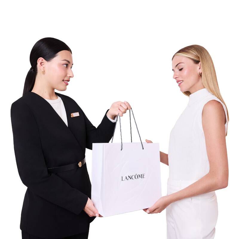 Lancome savjetnica za ljepotu uručuje personaliziranu bijelu Lancome vrećicu klijentici