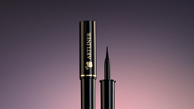 A sleek, black mascara tube and applicator against a gradient background.
