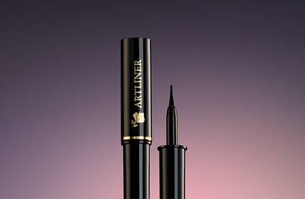 A sleek, black mascara tube and applicator against a gradient background.