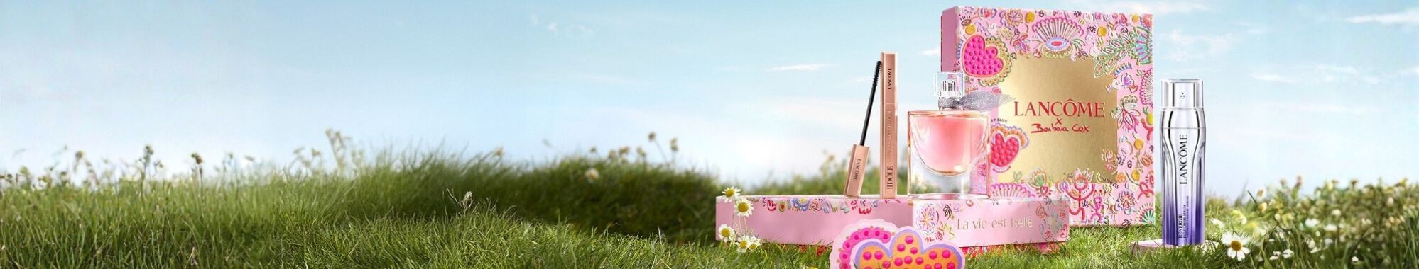 A visually striking display of beautifully wrapped gift boxes stacked in a pyramid shape against a dark background, with whimsical star and crescent moon illustrations scattered around.