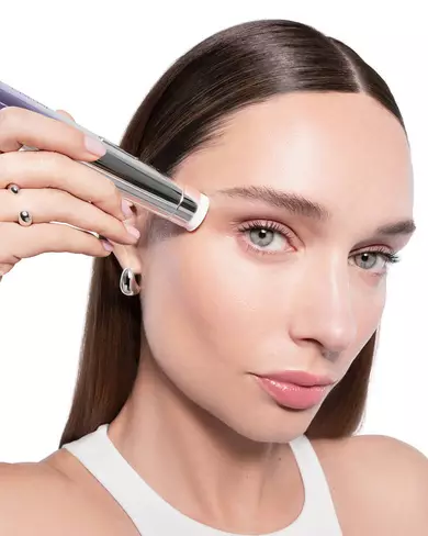: Žena demonstrira primjenu inovativnog Renergie Nano-Resurfacer 400 Booster uređaja za njegu lica.