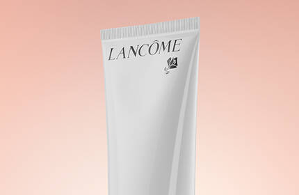 A Lancome skincare product displayed against a soft, warm gradient background.