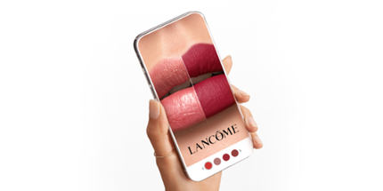 Mobilni telefon prikazuje različite nijanse ruža za usne brenda Lancome. Osoba drži telefon u ruci.