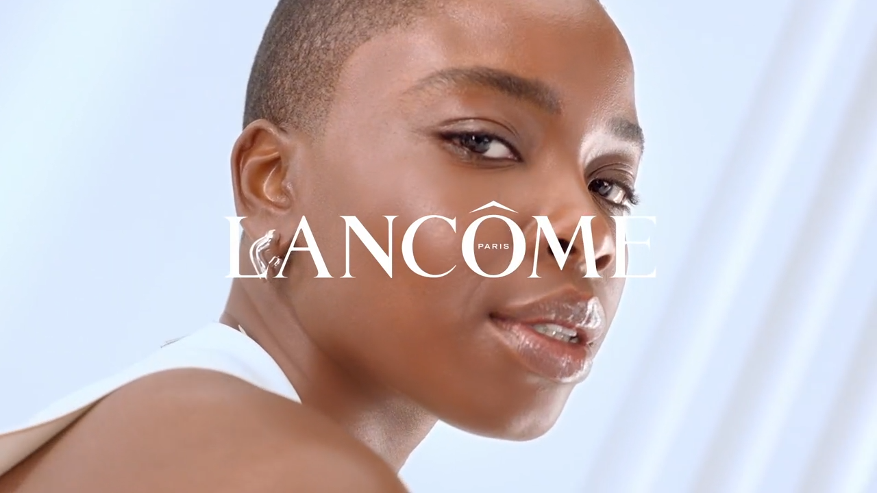 Promocijski prikaz modela s kratkom frizurom, uz logo Lancôme Paris, u svijetlom pozadinskom okruženju.